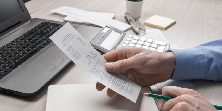 Como fazer um comprovante de renda - pessoa organizando documentos financeiros no escritório